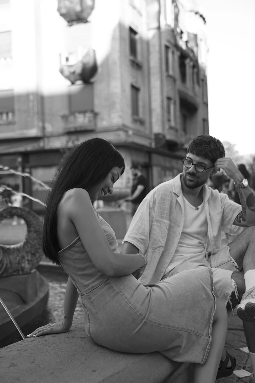 Couple sitting by the fountain in central Timișoara, black and white photo