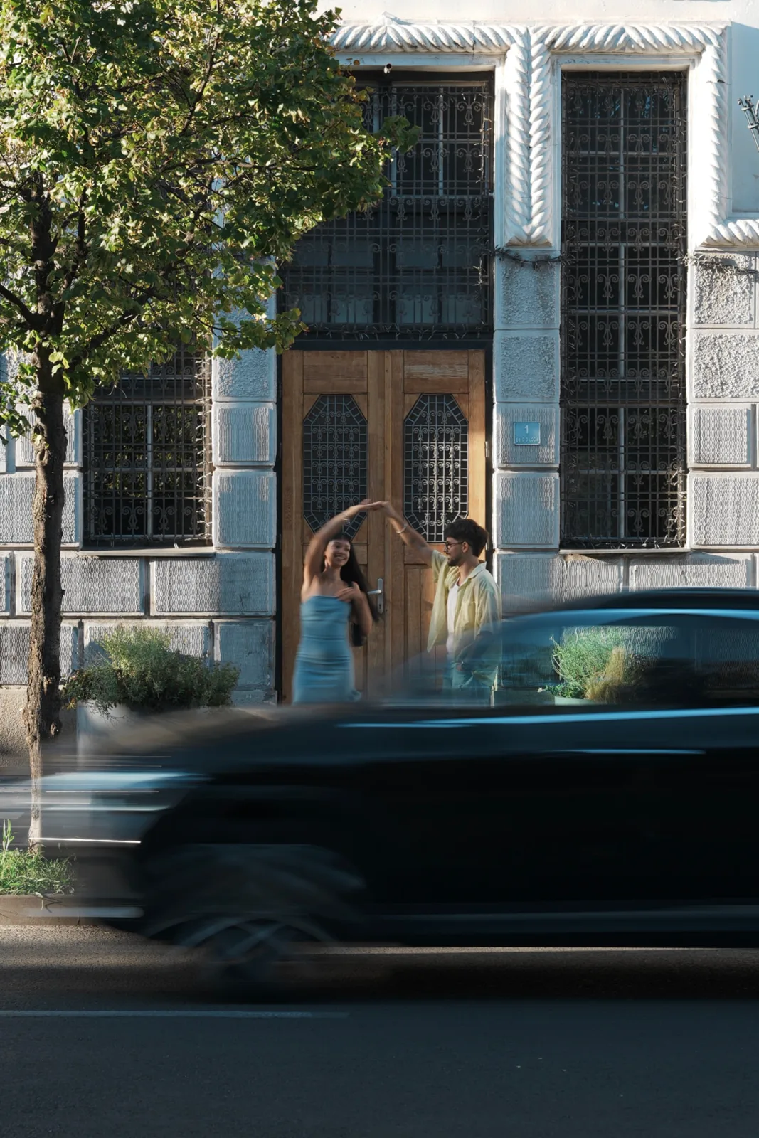Couple dancing in front of an old door on a street in Timișoara