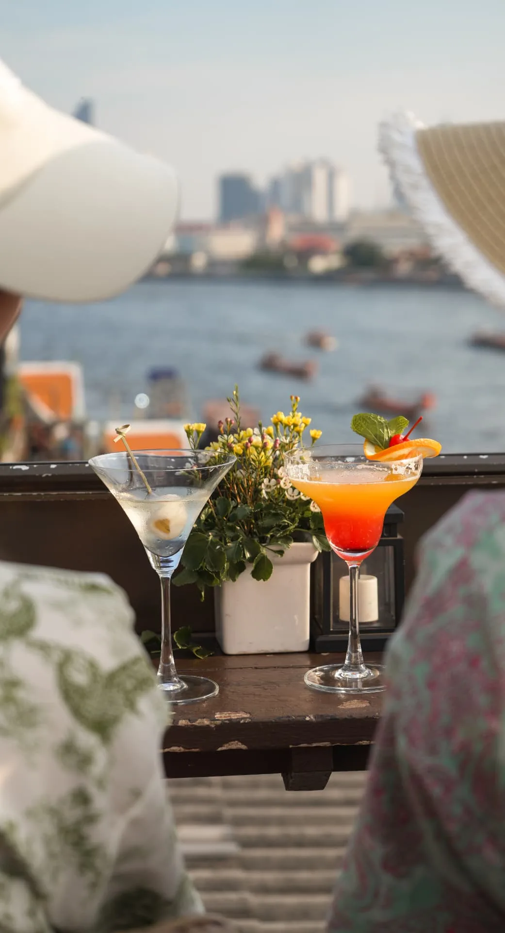 Două cocktailuri pe o terasă cu vedere la apă
